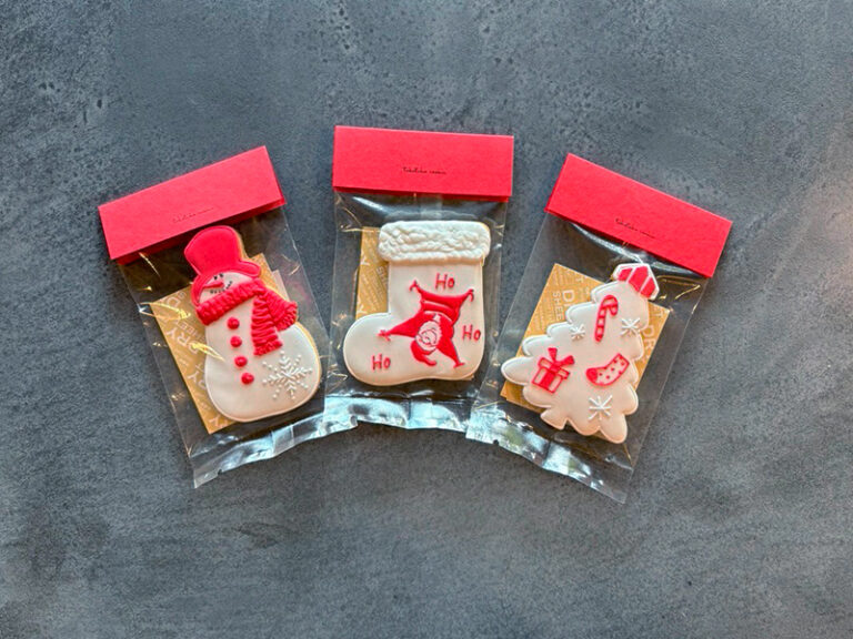 clastaのクリスマスアイシングクッキー。スノーマン、靴下、ツリーの形がそれぞれ色鮮やかにデコレーションされている