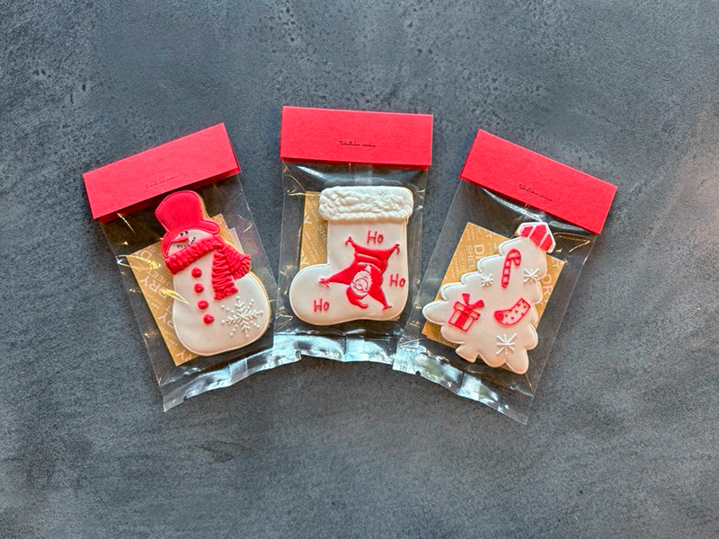 clastaのクリスマスアイシングクッキー。スノーマン、靴下、ツリーの形がそれぞれ色鮮やかにデコレーションされている