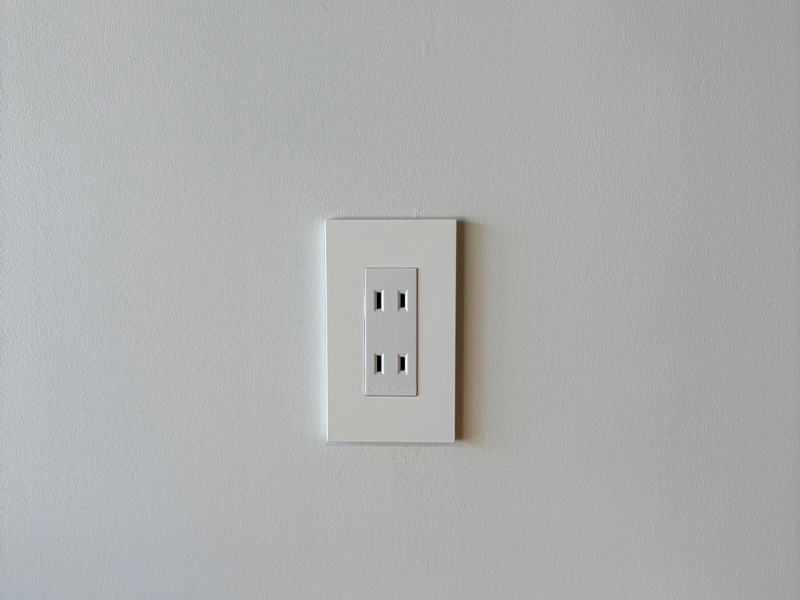 clastaの壁に設置された白いプレートの電源コンセント。フラットでミニマルなデザインが印象的