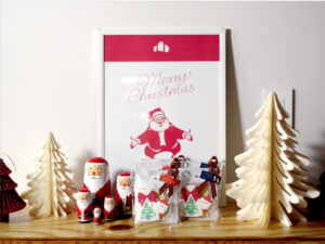 撮影用にディスプレイされたクリスマスシーン。サンタのマトリョーシカと“Merry Christmas”のポスターを背景に、トコトコクッキー製のクリスマス限定アイシングクッキーが並んでいる。