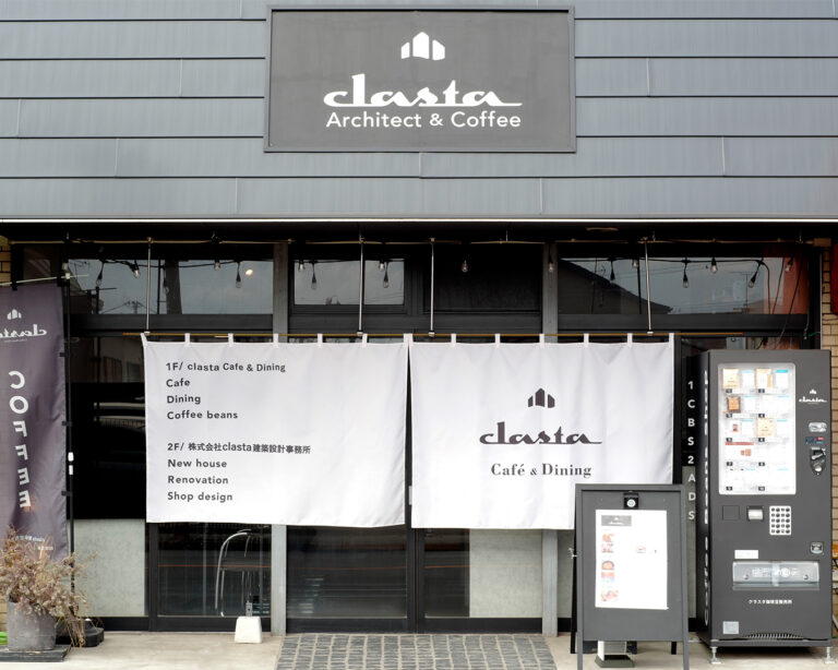 Clasta Café & Dining の外観。白いのれんにロゴが入り、1階はカフェ、2階は建築設計事務所の案内が書かれている。Architect & Coffee のサインが掲げられている店舗外観。